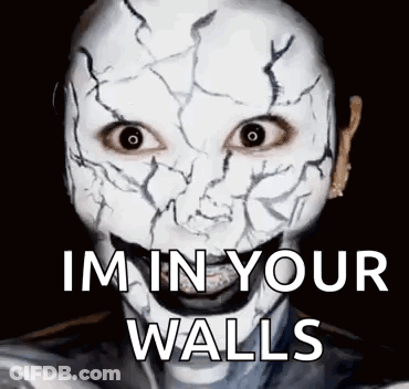 A Person Wearing A White Mask With A Cracked Face And The Words `` I 'M In Your Walls '' . GIF