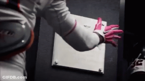 A Person Wearing A White Shirt And Pink Gloves Is Holding A White Board . GIF