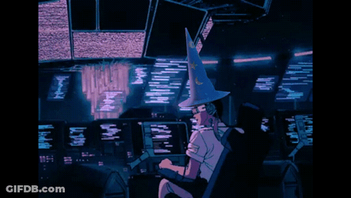 A Person Wearing A Witch Hat Is Sitting In Front Of A Computer Monitor GIF