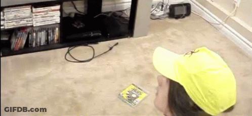 A Person Wearing A Yellow Hat Is Looking At A Dvd GIF