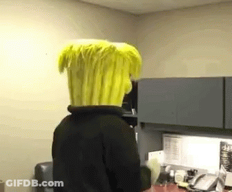 A Person Wearing A Yellow Wig Is Standing In A Room GIF