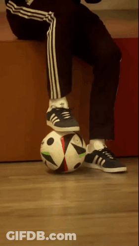 A Person Wearing Adidas Shoes Is Balancing A Soccer Ball On Their Knee GIF