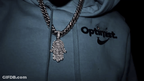A Person Wearing An Optimistic Hoodie With A Hamsa Pendant GIF