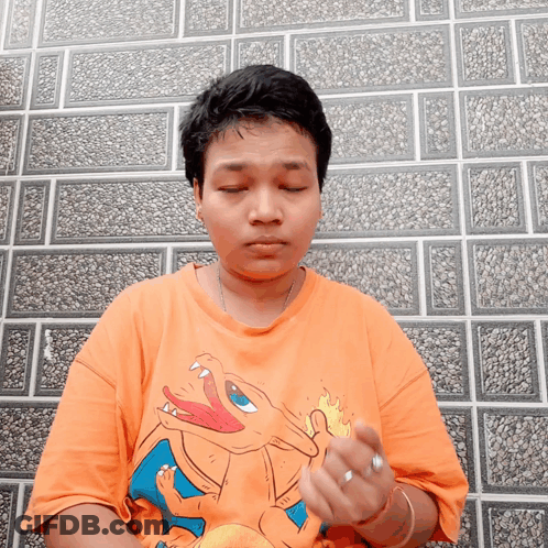 A Person Wearing An Orange Shirt With A Picture Of A Dragon On It GIF