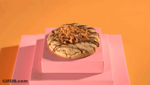 A Person Wearing Black Gloves Pours A Cookie With A Spoon GIF