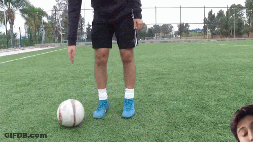 A Person Wearing Blue Adidas Shorts Kicks A Soccer Ball GIF