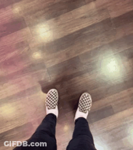 A Person Wearing Checkered Shoes Standing On A Wood Floor GIF