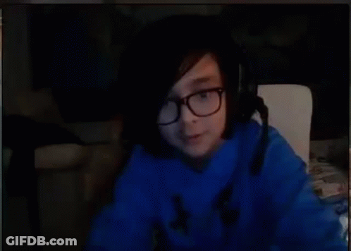A Person Wearing Glasses And A Blue Sweater Is Sitting In Front Of A Computer Screen . GIF
