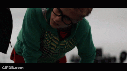 A Person Wearing Glasses And A Green Shirt Is Laying On Their Back GIF