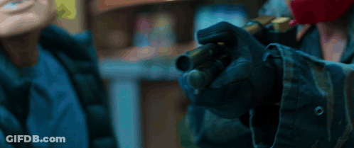 A Person Wearing Gloves Is Holding A Gun In Their Hand . GIF