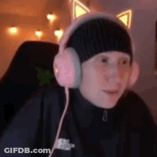 A Person Wearing Headphones And A Hat With Cat Ears Is Sitting In A Chair . GIF