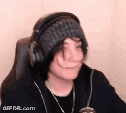 A Person Wearing Headphones And A Knitted Hat Is Sitting In A Chair . GIF