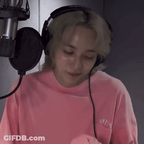 A Person Wearing Headphones And A Pink Shirt With The Word N On The Front GIF