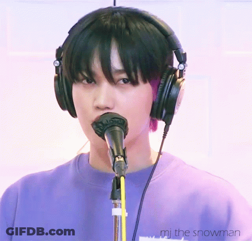 A Person Wearing Headphones Is Singing Into A Microphone With The Words " Mj The Snowman " Below Them GIF