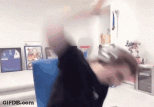 A Person Wearing Headphones Is Sitting At A Desk In A Room With Pictures On The Wall . GIF