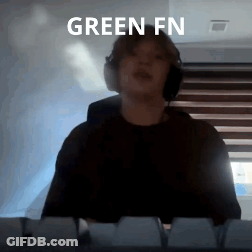 A Person Wearing Headphones Is Standing In Front Of A Keyboard With The Words Green Fn Written Above Them GIF