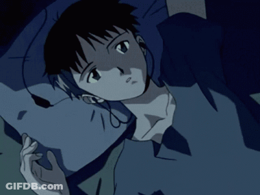 A Person Wearing Headphones Laying On A Bed With A Blue Shirt On GIF