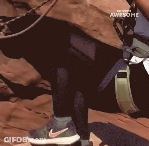 A Person Wearing Nike Shoes Climbs A Rocky Hillside GIF