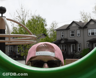 A Person Wearing Sunglasses And A Pink Hat Looks Out Of A Green Circle GIF