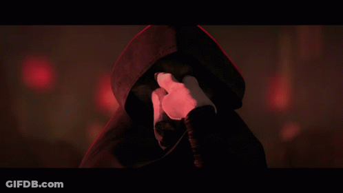 A Person With A Hood On Covering Their Face With Their Hands GIF