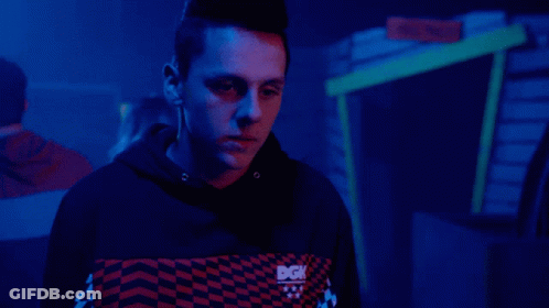 A Person With A Mohawk Stands In Front Of A Cactus GIF