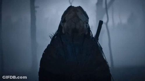 A Person With A Skull On Their Head Holding A Sword In The Fog GIF