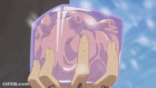 A Person With A Tattoo On Their Hand Is Holding A Heart In Their Hands GIF