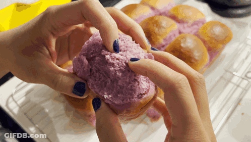 A Person With Blue Nails Is Holding A Purple Donut GIF