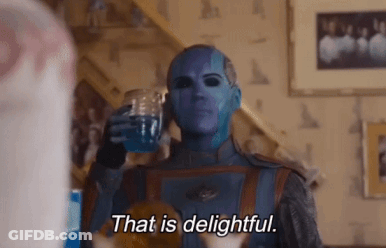 A Person With Blue Paint On Their Face Is Holding A Glass Of Water And Saying That Is Delightful GIF