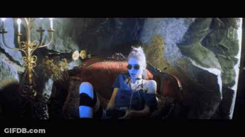 A Person With Blue Paint On Their Face Is Sitting On A Couch GIF