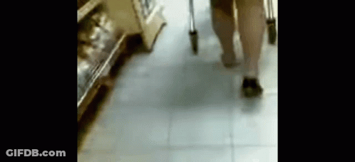 A Person With Crutches Is Walking Down A Tiled Floor In A Store . GIF