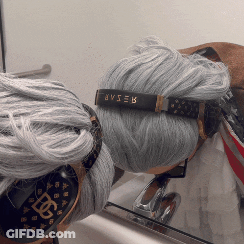 A Person With Gray Hair Wearing Headphones With Bvser Written On Them GIF