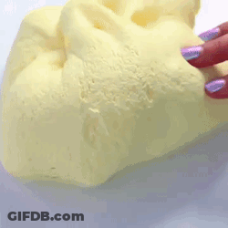 A Person With Purple Nails Is Holding A Piece Of Yellow Foam . GIF