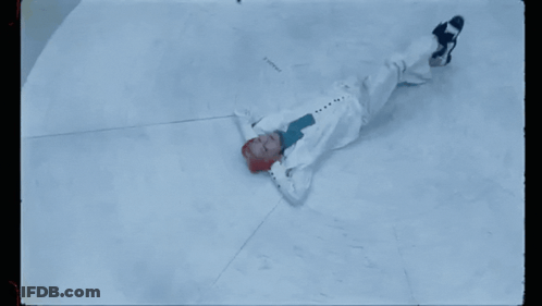 A Person With Red Hair Is Laying On The Ground GIF