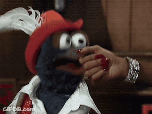 A Person With Red Nails Is Touching A Stuffed Animal With A Red Hat GIF