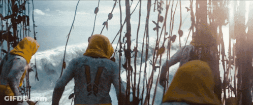 A Person With The Number 14 On Their Back Stands In Front Of A Body Of Water GIF