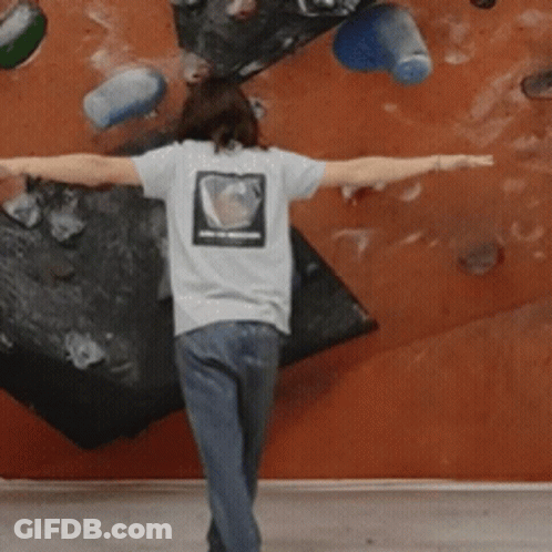 A Person With Their Arms Outstretched In Front Of A Wall GIF