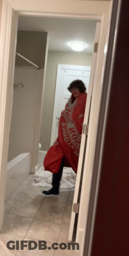 A Person Wrapped In A Budweiser Blanket In A Bathroom GIF