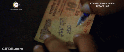 A Person Writing On A 10 Rupee Note GIF