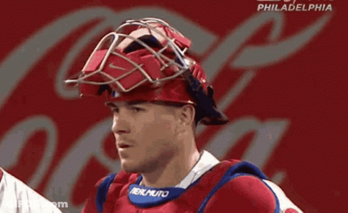 A Philadelphia Baseball Player Wearing A Helmet With A Coca Cola Logo Behind Him GIF