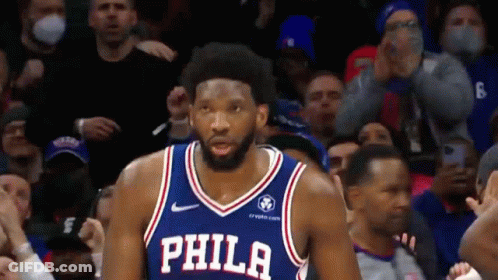 A Philadelphia Basketball Player Is Standing In Front Of A Crowd Of People . GIF