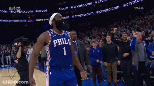 A Philadelphia Basketball Player Stands In Front Of A Crowd With His Fist In The Air GIF