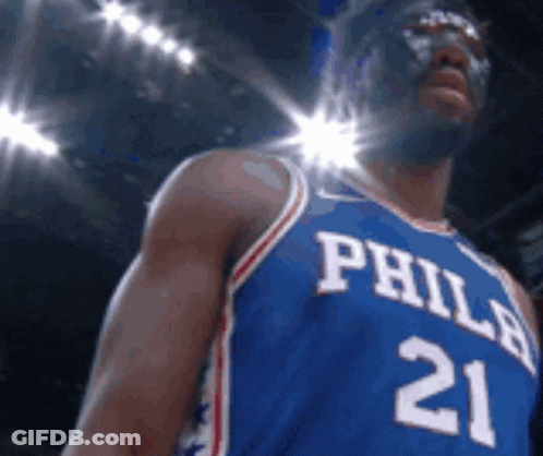 A Philadelphia Basketball Player Wearing A Mask And Jersey Number 21 GIF