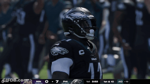 A Philadelphia Eagles Player Is Holding A Football In Front Of A Crowd GIF