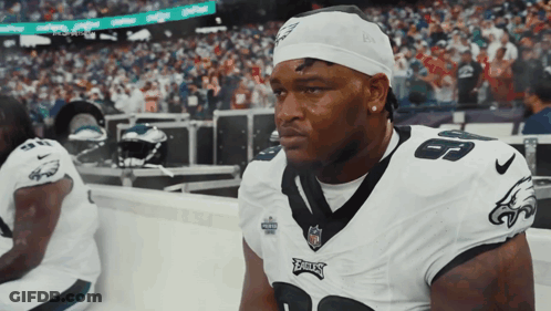 A Philadelphia Eagles Player Sits On The Sidelines During A Game GIF