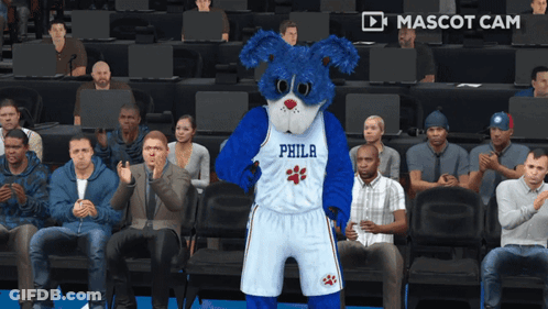 A Philadelphia Mascot Is Standing In Front Of A Crowd Of People GIF