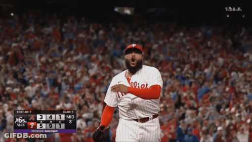 A Philadelphia Phillies Baseball Player Stands In Front Of A Scoreboard GIF