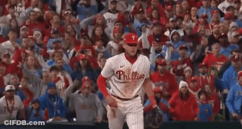 A Phillies Baseball Player Is Standing In Front Of A Crowd Of People . GIF