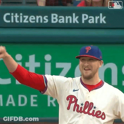 A Phillies Baseball Player Stands In Front Of A Citizen 'S Bank Park Banner GIF