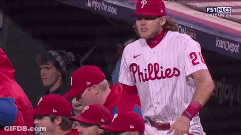 A Phillies Baseball Player Stands In The Dugout With His Teammates GIF